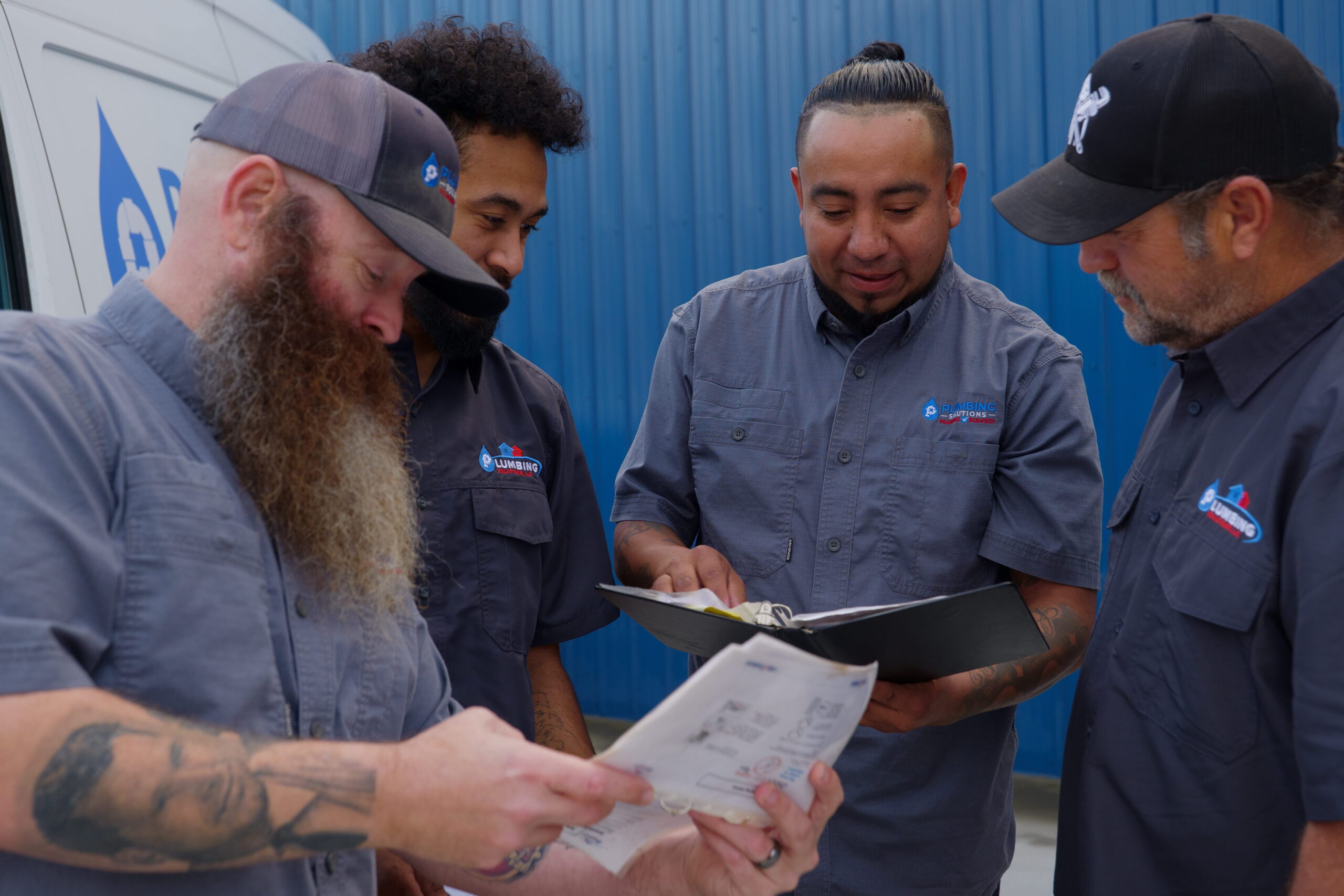 Plumbing Solutions LLC team reviewing project paperwork together