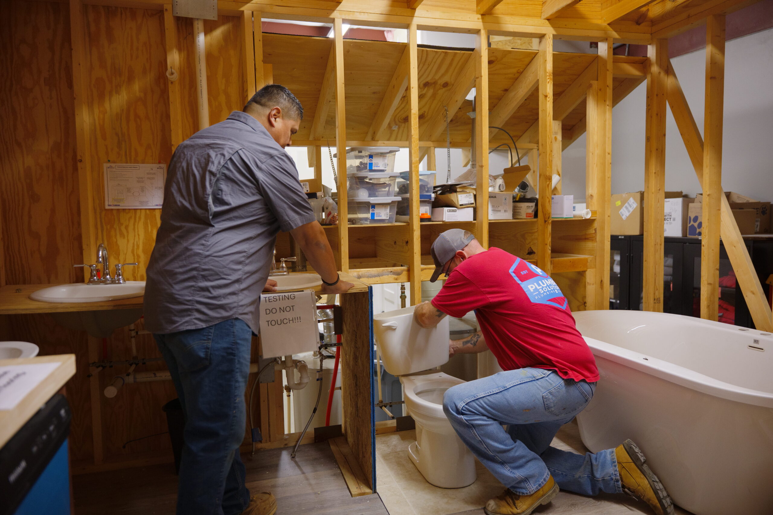 Plumbing Solutions LLC team testing a toilet installation during training
