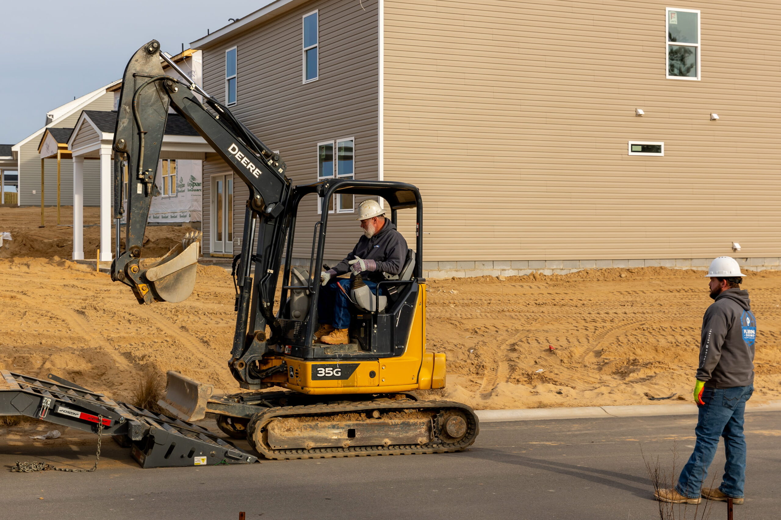 Plumbing Solutions LLC crew using an excavator for new home plumbing work