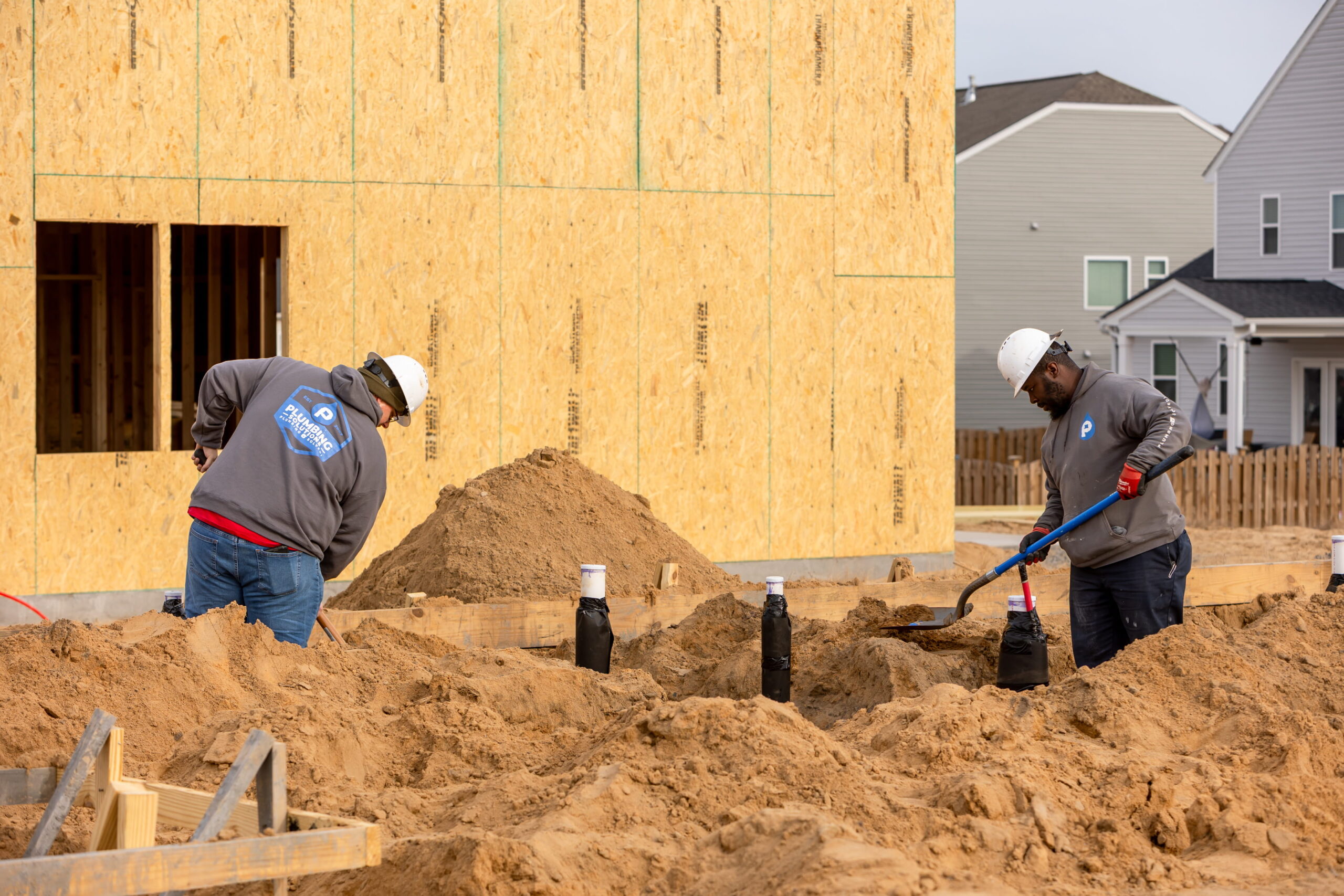Plumbing Solutions LLC plumbers digging trenches for new home plumbing installation.