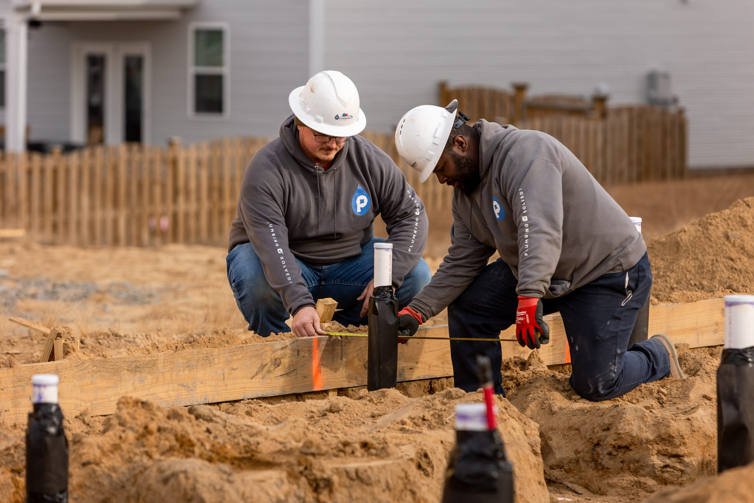 Plumbing Solutions LLC crew installing plumbing lines at a new home site