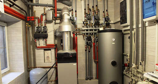 Plumbing Solutions LLC modern tank and tankless water heater system installation with connected pipes and valves.