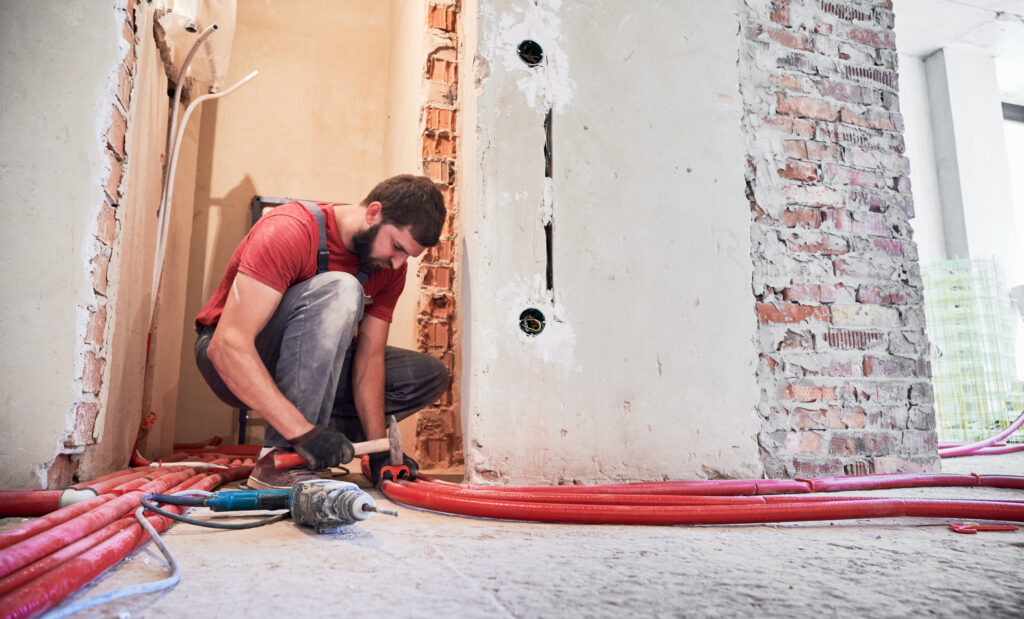 Plumbing Solutions LLC technician installing replacement under-slab piping during slab leak repair service.