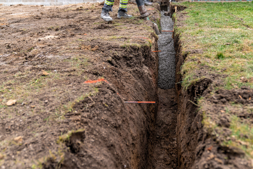Plumbing Solutions LLC crew preparing a yard excavation area for trenchless sewer line repair access.