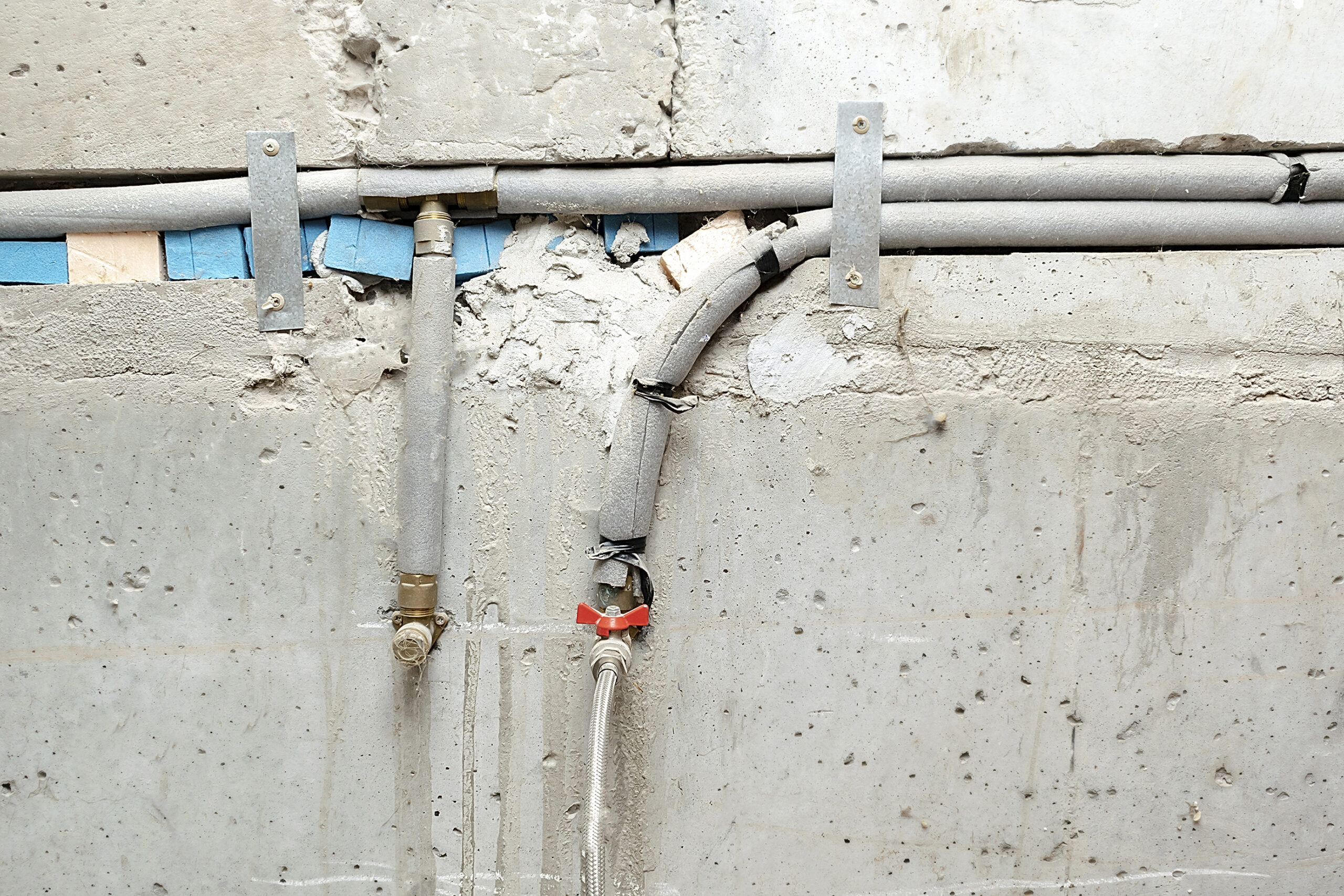 Exposed under-slab plumbing pipes showing corrosion and wear during professional leak inspection by Plumbing Solutions LLC.