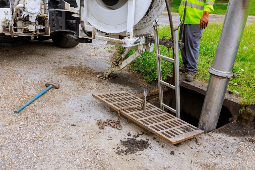 Plumbing Solutions LLC technician accessing a sewer manhole using professional equipment during sewer line inspection and repair.