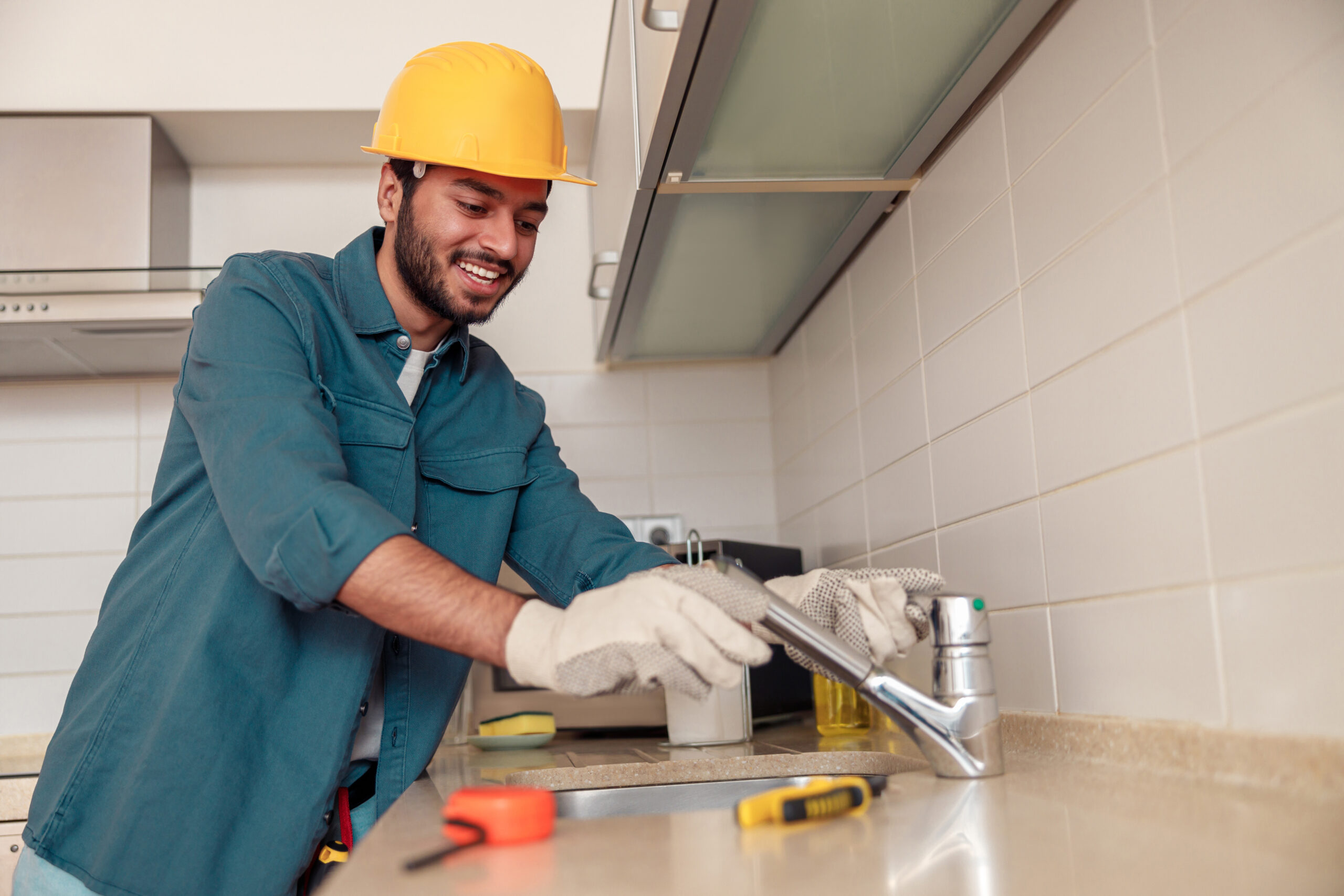 Plumbing Solutions LLC technician installing a kitchen faucet during residential kitchen plumbing service.