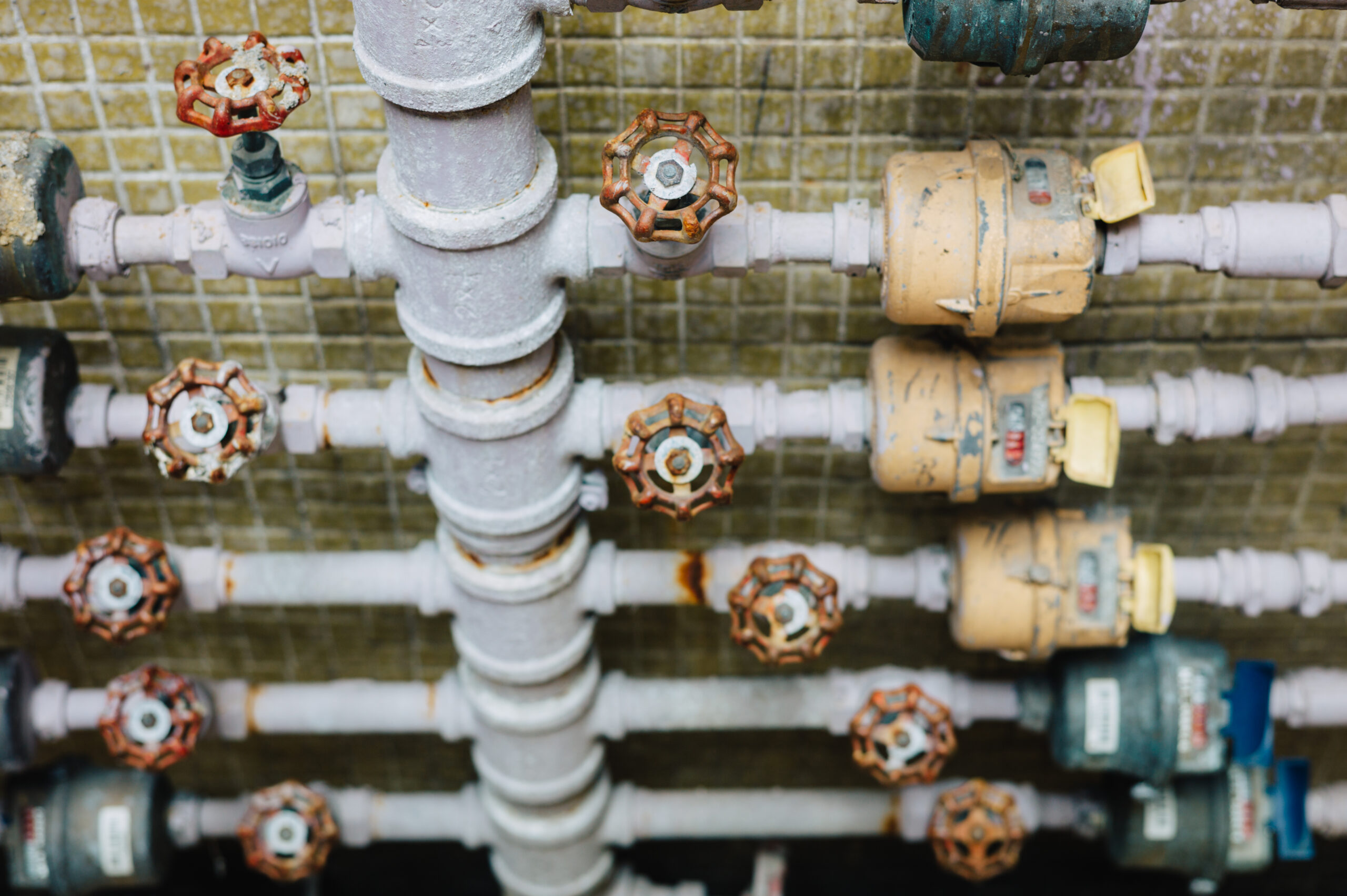 Backflow testing valves and commercial water meter piping installed in a plumbing system by Plumbing Solutions LLC.