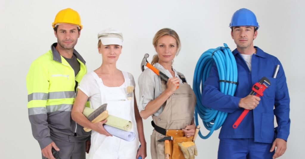 A team of Plumbing Solutions LLC technicians stand together in uniform holding plumbing and construction tools, ready for residential and commercial service.