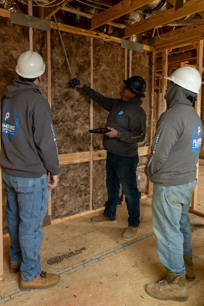 Plumbing Solutions LLC team reviewing plumbing layouts before beginning a whole-house repiping installation inside a residential home.