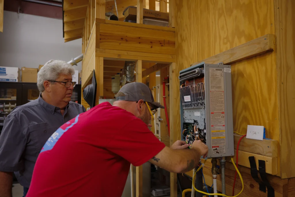 Professional plumber examining a water heater tank and checking for potential issues.