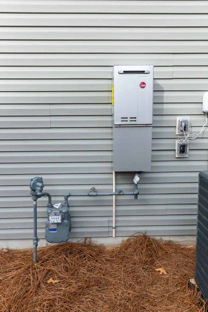 Close-up view of a water heater plumbing system showing pipes and connections during inspection.